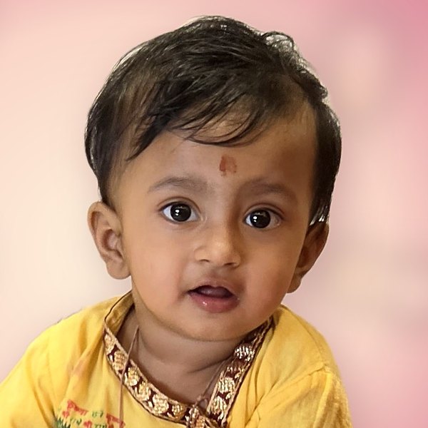 Baby Hridaya smiling in a yellow kurta